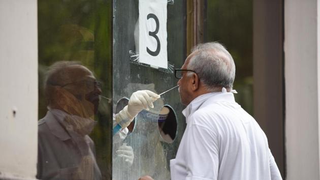 A health worker collects a swab sample from a man to test for coronavirus infecton at Swami Parmanand Prakritik Chikitsalaya Yoga and Anusandhan Kendra in New Delhi. (Raj K Raj/HT PHOTO) A health worker collects a swab sample from a man to test for coronavirus infecton at Swami Parmanand Prakritik Chikitsalaya Yoga and Anusandhan Kendra in New Delhi. (Raj K Raj/HT PHOTO)