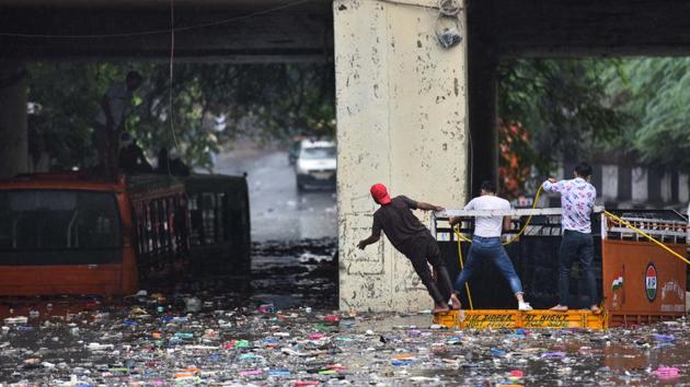 Peoplebeing rescued from a submerged bus that was stuck under the Zakhira Bridge in New Delhi on July 19. The India Meteorological Department (IMD) said the Safdarjung Observatory, which provides representative figures for the city, recorded 74.8mm rainfall till 8:30am in Delhi, HT reported. (Sanchit Khanna / HT Photo)
