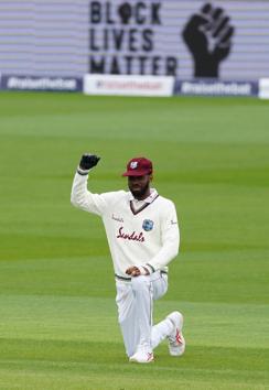 Cricket - Second Test - England v West Indies - Emirates Old Trafford, Manchester, Britain - July 16, 2020 West Indies' Roston Chase wears a black glove as he kneels in support of the Black Lives Matter campaign before the start of play, as play resumes behind closed doors following the outbreak of the coronavirus disease (COVID-19) Jon Super/Pool via REUTERS (REUTERS) Cricket - Second Test - England v West Indies - Emirates Old Trafford, Manchester, Britain - July 16, 2020 West Indies' Roston Chase wears a black glove as he kneels in support of the Black Lives Matter campaign before the start of play, as play resumes behind closed doors following the outbreak of the coronavirus disease (COVID-19) Jon Super/Pool via REUTERS (REUTERS)