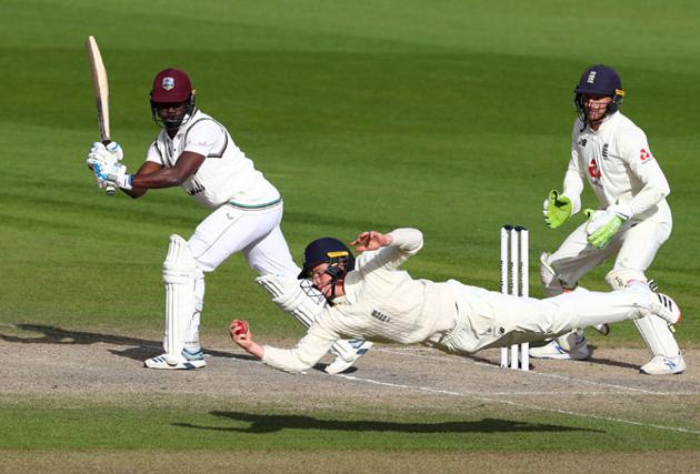 Ollie Pope takes a sharp catch at forward shot leg to dismiss the last West Indies batsman Kemar Roach off the bowling of Dom Bess to win the second Test for England. (Getty Images)