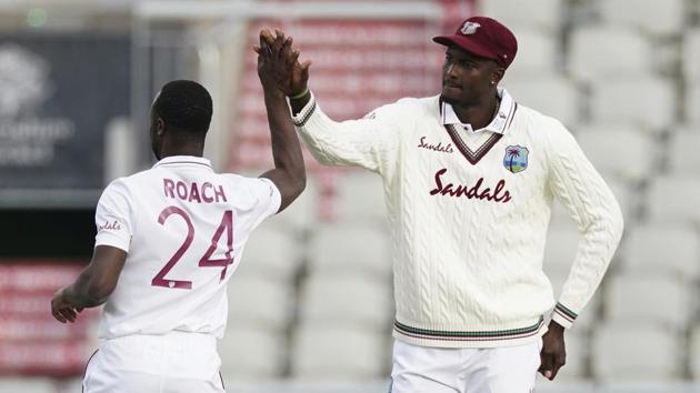 West Indies' Kemar Roach, left, celebrates with captain Jason Holder the dismissal of England's Zak Crawley. (AP)