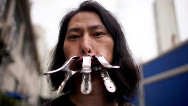 Brother Nut, Chinese performance artist with three metallic clips sealing his mouth, poses for a picture in Shanghai, following the coronavirus disease (COVID-19) outbreak, China July 13, 2020. Picture taken July 13, 2020.(REUTERS) Brother Nut, Chinese performance artist with three metallic clips sealing his mouth, poses for a picture in Shanghai, following the coronavirus disease (COVID-19) outbreak, China July 13, 2020. Picture taken July 13, 2020.(REUTERS)