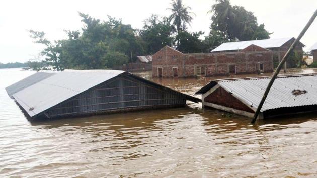 Houses seen submerged in the flood-affected area as the water level of Barpani river rises, in Assam’s Nagaon district on Sunday.(ANI Photo)