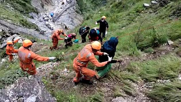 Teams of National Disaster Response Force (NDRF) and State Disaster Response Force (SDRF) rescue people near Pipalkoti in Chamoli on Monday,July 20, 2020 . They were stranded due to the closure of Badrinath National Highway owing to landslide.(ANI)
