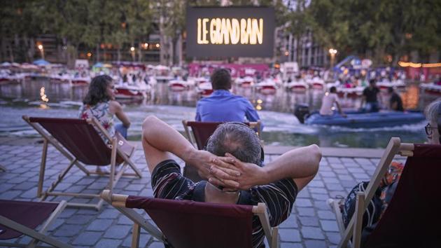 Parisians enjoy the opening night of the Paris Plages at La Villette, on July 18. As part of the festival 38 electric boats were installed on the Seine’s quays in compliance with social distancing rules, with 150 deckchairs on the banks of the canal. The screenings included the short film ‘Corona Story’ by Victor Mirabel, followed by the comedy ‘Le Grand Bain’, which also included free ice cream. (Kiran Ridley / Getty Images) Parisians enjoy the opening night of the Paris Plages at La Villette, on July 18. As part of the festival 38 electric boats were installed on the Seine’s quays in compliance with social distancing rules, with 150 deckchairs on the banks of the canal. The screenings included the short film ‘Corona Story’ by Victor Mirabel, followed by the comedy ‘Le Grand Bain’, which also included free ice cream. (Kiran Ridley / Getty Images)