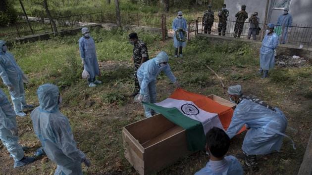 Indian paramilitary soldiers cover the coffin of their colleague who died of Covid-19, at a crematorium in Srinagar.(AP)