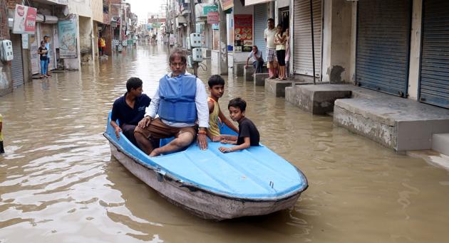 Vijay Kumar Sharma, a former municipal councillor of Bathinda, taking a boat ride through a lane in the inundated Parasram Nagar after Tuesday’s downpour. (Sanjeev Kumar/HT) Vijay Kumar Sharma, a former municipal councillor of Bathinda, taking a boat ride through a lane in the inundated Parasram Nagar after Tuesday’s downpour. (Sanjeev Kumar/HT)