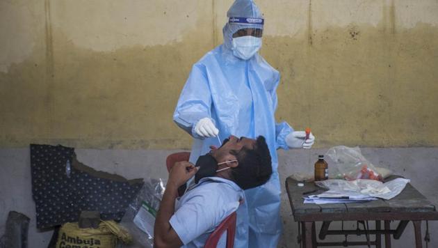 A doctor takes a swab of the resident at Trombay in Mumbai, India on Monday, July 20, 2020. (Pratik Chorge/HT Photo)