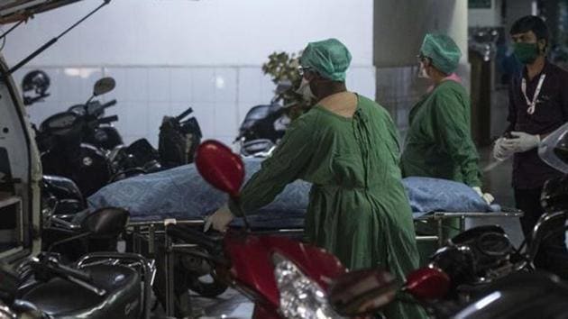 Medical staff of a private hospita transport the dead body of a 52-year-old coronavirus patient who died at a private hospital in Pune.(Pratham Gokhale/HT Photo)