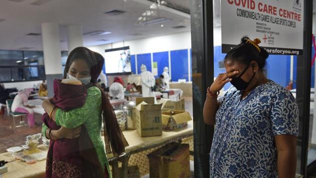 A visitor gets emotional seeing her Covid-19 positive relative and her newborn inside the CWG Sports Complex Covid-19 Care Centre in New Delhi on July 20. The health ministry told PTI on July 20 that medical attention is being provided to all active cases in hospitals and in home isolation and the number of recovered COVID-19 patients exceeds India’s active caseload by 309,627. (Ajay Aggarwal / HT Photo) A visitor gets emotional seeing her Covid-19 positive relative and her newborn inside the CWG Sports Complex Covid-19 Care Centre in New Delhi on July 20. The health ministry told PTI on July 20 that medical attention is being provided to all active cases in hospitals and in home isolation and the number of recovered COVID-19 patients exceeds India’s active caseload by 309,627. (Ajay Aggarwal / HT Photo)