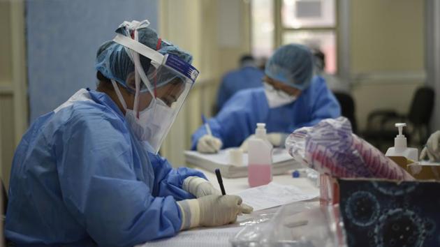Medical professionals wearing PPE coveralls seen at work at Lok Nayak Jai Prakash (LNJP) Hospital in New Delhi on July 21. The samples collected during the survey were tested in labs for Immunoglobulin G (IgG) antibodies. (Vipin Kumar / HT Photo)