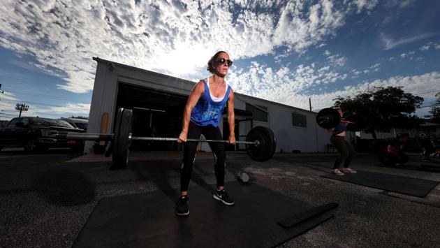Sammi Simon power lifts during an outdoor Jetty Gym “Outside The Box” fitness workout on July 20 in Oceanside, New York. City officials are concerned are about a second wave sweeping back into the city. Many indoor activities are still barred and New Yorkers will need to wait a little longer for gyms, museums and shopping malls to reopen. (Al Bello / Getty Images / AFP)