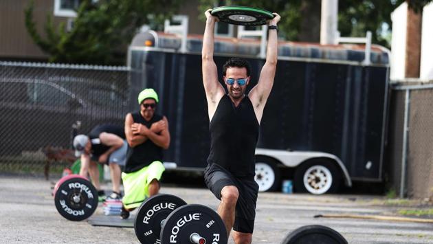 Evan Lieberman lunges with a weight held over his head during an outdoor workout on July 20 in New York. New York Governor Andrew Cuomo announced on July 17 that gyms will not be permitted to reopen during Phase 4 until New York's Health Department determines if air filtering systems are circulating the coronavirus. (Al Bello / Getty Images / AFP)