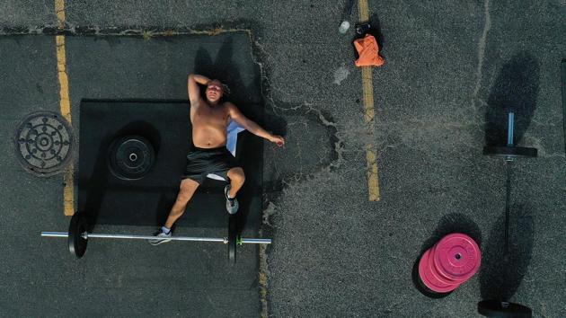 Frank Wroblewski, after exhaustion from an outdoor workout session on July 20 in Oceanside, New York. With the latest phase, New Yorkers can expect the return of low-risk outdoor arts and entertainment at reduced capacity. Professional sports will resume, albeit with one major caveat: no fans. (Al Bello / Getty Images / AFP)
