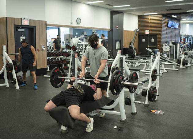 Members wearing protective masks lift weights at a GoodLife Fitness Centers Inc. gym on its first day of reopening in Ottawa, Ontario, Canada, on Friday, July 17, 2020. (Bloomberg)