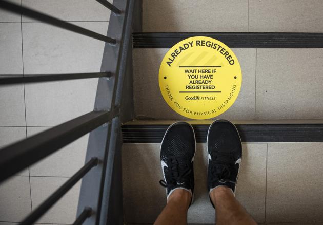 A sticker on the floor indicates where members should stand upon entering at a GoodLife Fitness Centers Inc. gym on its first day of reopening in Ottawa, Ontario, Canada, on Friday, July 17, 2020. (Bloomberg)