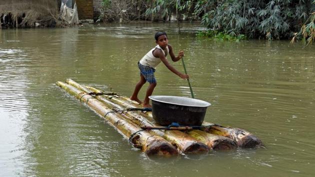 A boy transports a pot on a makeshift raft through a flooded area in Morigaon district, in the northeastern state of Assam on July 20, 2020.(Reuters Photo) A boy transports a pot on a makeshift raft through a flooded area in Morigaon district, in the northeastern state of Assam on July 20, 2020.(Reuters Photo)