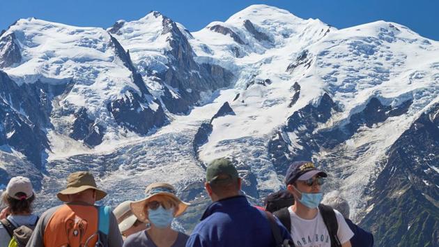 Tourists wearing masks take a look at the Mont-Blanc mountain from Le Brevent, during the coronavirus disease (COVID-19) outbreak, in Chamonix, France, July 20, 2020. (REUTERS)