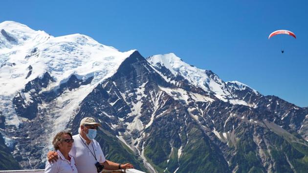 Tourists pose for a picture with the Mont-Blanc mountain from Le Brevent, during the coronavirus disease (COVID-19) outbreak, in Chamonix, France, July 20, 2020. (REUTERS)