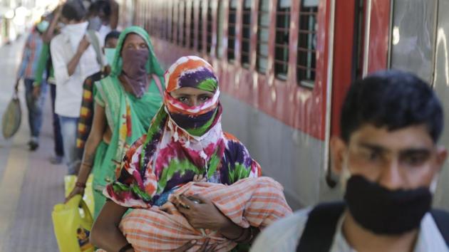 Migrant workers stand to board a special train to return to Agra in Uttar Pradesh state, during a nationwide lockdown to curb the spread of new coronavirus, at a railway station in Ahmedabad. (AP) Migrant workers stand to board a special train to return to Agra in Uttar Pradesh state, during a nationwide lockdown to curb the spread of new coronavirus, at a railway station in Ahmedabad. (AP)