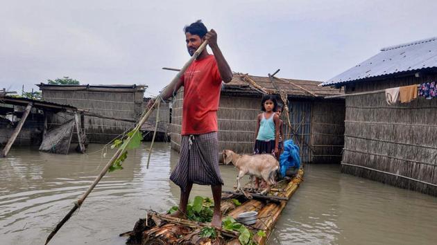 A villager rows a makeshift raft to cross the flooded Puthimari village, in Darrang district of Assam, Tuesday, July 21, 2020.(PTI)