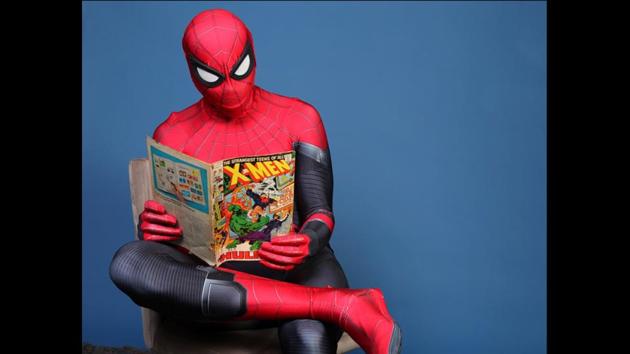Evan Nuzum, dressed as Spider-Man, reads a comic book on day one of Comic-Con International in San Diego on July 18, 2019. (Rebecca Cabage/Invision/AP)