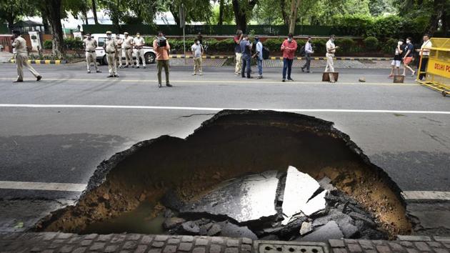 A section of Ashoka Road caved-in due to waterlogging on July 22. It caused a 10-feet fissure, forcing Delhi traffic police to cordon the stretch off and divert traffic. Portions of the roads also caved-in on the Mahipalpur bypass and the link road near Nawada metro station on July 22. (Vipin Kumar / HT photo)