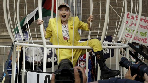 Fashion designer Vivienne Westwood stands in a giant bird cage in protest against the extradition of WikiLeaks founder Julian Assange to the U.S., outside the Old Bailey court, in London.(AP Photo/Matt Dunham)