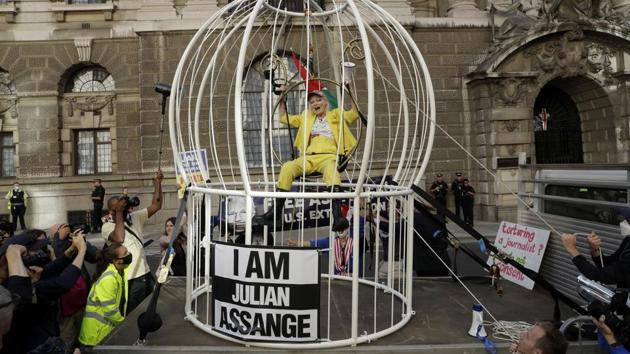 Fashion designer Vivienne Westwood sits suspended in a giant bird cage that reads “I Am Julian Assange”. (AP Photo/Matt Dunham) Fashion designer Vivienne Westwood sits suspended in a giant bird cage that reads “I Am Julian Assange”. (AP Photo/Matt Dunham)