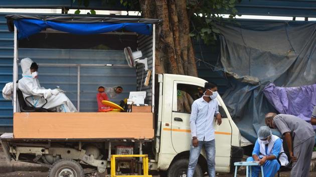 A health worker wearing PPE coveralls rests in the back of a collection vehicle after taking swab samples to test for coronavirus, near Minto Bridge in New Delhi.(Sanchit Khanna/HT PHOTO) A health worker wearing PPE coveralls rests in the back of a collection vehicle after taking swab samples to test for coronavirus, near Minto Bridge in New Delhi.(Sanchit Khanna/HT PHOTO)