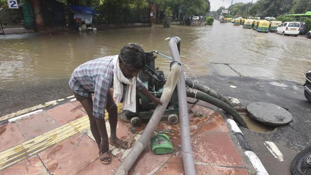 A PWD worker clears Jawaharlal Nehru Marg using a motor pump in New Delhi on July 22. Delhi PWD minister Satyendar Jain said, “Our priority is to clear roads of waterlogging immediately and for this we have deployed 1,400 pumps all over the city. In case of high-intensity rain, there may be waterlogging on streets at certain places but I assure that it would be cleared immediately,” HT reported. (Sonu Mehta / HT Photo)