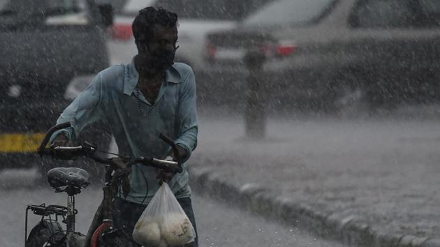 File photo: A man pushes his cycle amid heavy rain. (Biplov Bhuyan/HT PHOTO) File photo: A man pushes his cycle amid heavy rain. (Biplov Bhuyan/HT PHOTO)