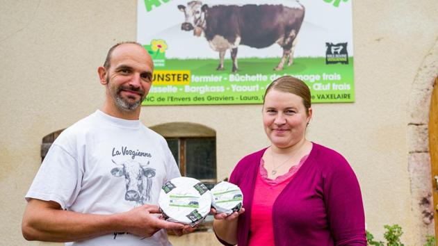 French farmers Lionel Vaxelaire and Laura Vaxelaire pose with their cheese named “Le Confiné ” in front of their cheese dairy in Saulxures-sur-Moselotte, Eastern France on July 17. The couple created a new cheese named “Le Confiné ” after they forgot a batch of their unsold cheese in the cellar during the coronavirus lockdown. (Jean Christophe Verhaegen / AFP) French farmers Lionel Vaxelaire and Laura Vaxelaire pose with their cheese named “Le Confiné ” in front of their cheese dairy in Saulxures-sur-Moselotte, Eastern France on July 17. The couple created a new cheese named “Le Confiné ” after they forgot a batch of their unsold cheese in the cellar during the coronavirus lockdown. (Jean Christophe Verhaegen / AFP)
