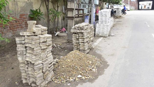 Uprooted old tiles lying on the roadside in Singhpura area near Jagroan bridge in Ludhiana on Wednesday.(Gurpreet Singh/HT)
