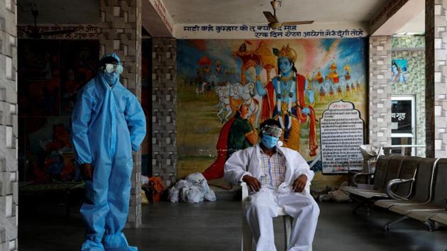 A priest and a labourer wear personal protective equipment (PPE) at a crematorium amid the spread of the coronavirus disease.(REUTERS)