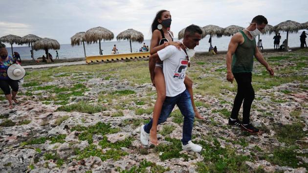 Naomi Ramos is carried by her father during a photo session for her quinceanera celebration amid coronavirus disease. (REUTERS/Alexandre Meneghini)