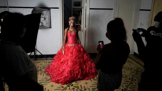 Naomi Ramos poses as she tries dresses for her quinceanera (coming of age of 15-year-olds) celebration amid coronavirus disease (Covid-19) spread concerns, in Havana, Cuba. (REUTERS/Alexandre Meneghini)
