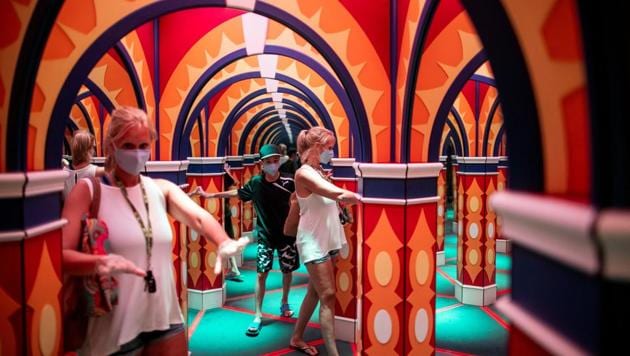 People walk through a house of mirrors attraction in Niagara Falls, Ontario, Canada July 21, 2020.(REUTERS)