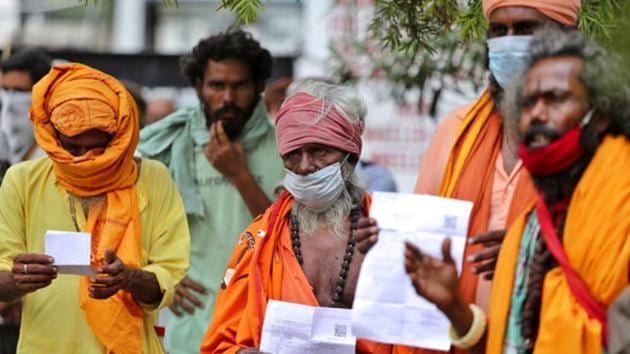 Hindu holy men wearing face masks wait to consult doctors at a Covid-19 screening facility inside a government hospital in Jammu, India, Tuesday, July 21, 2020.(AP) Hindu holy men wearing face masks wait to consult doctors at a Covid-19 screening facility inside a government hospital in Jammu, India, Tuesday, July 21, 2020.(AP)