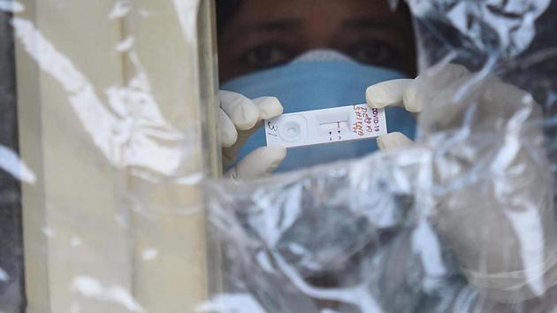 A health worker holds up a Covid-19 rapid antigen test kit at the Nehru Homeopathic Medical College and Hospital in Defence Colony, New Delhi.(Raj K Raj/ Hindustan Times)