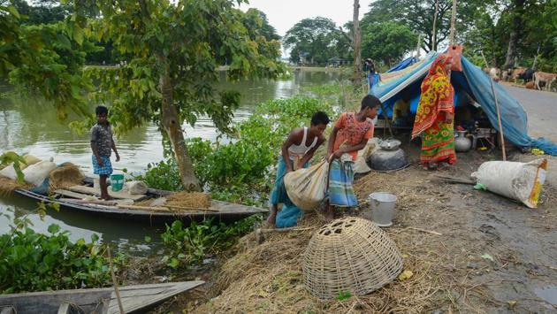Villagers unload their belongings from a boat on reaching a higher land, after the low-lying areas were submerged under flood waters in Morigaon district on July 23. The rising water levels have damaged embankments, roads, bridges, and culverts, among other constructions like houses in the state. (PTI)