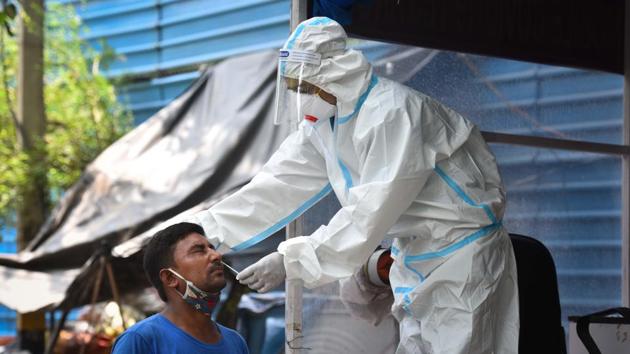 A health worker wearing PPE coveralls collects swab samples to test for coronavirus. (Sanchit Khanna/HT PHOTO) A health worker wearing PPE coveralls collects swab samples to test for coronavirus. (Sanchit Khanna/HT PHOTO)