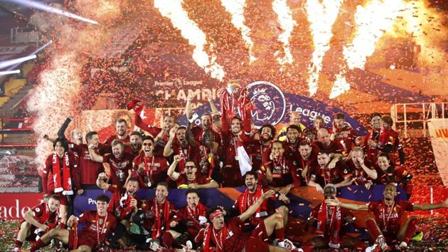 Liverpool's Jordan Henderson holds the English Premier League trophy aloft after it was presented. (AP)