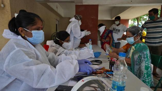 File photo: Health workers wearing protective gears record details of the residents during a check-up campaign for the coronavirus disease (COVID-19) in Mumbai.(REUTERS)