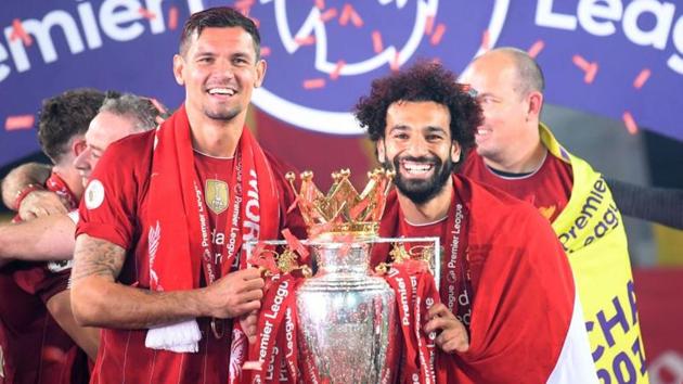 Liverpool's Dejan Lovren and Mohamed Salah celebrate with the trophy after winning the Premier League. (Pool via REUTERS)