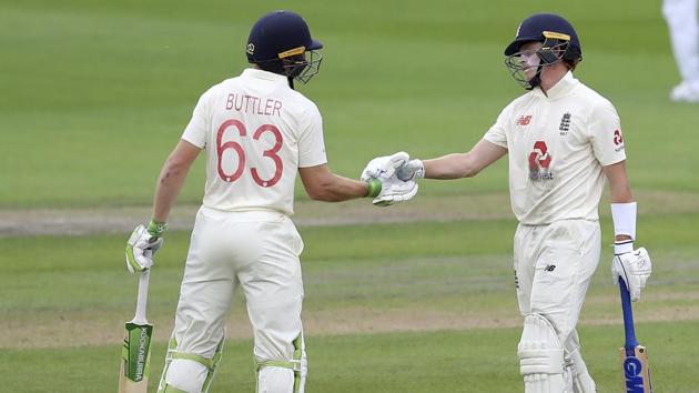 England's Jos Buttler, left, congratulates teammate Ollie Pope on scoring fifty runs during the first day of the third cricket Test match between England and West Indies at Old Trafford in Manchester, England, Friday, July 24, 2020. (AP) England's Jos Buttler, left, congratulates teammate Ollie Pope on scoring fifty runs during the first day of the third cricket Test match between England and West Indies at Old Trafford in Manchester, England, Friday, July 24, 2020. (AP)
