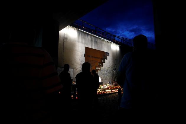 People stand near a memorial at the "Night of Lights" event to commemorate the victims of a deadly stampede during the 2010 Love Parade festival, at the former festival site on the eve of the disaster's 10th anniversary, in Duisburg, Germany, July 23, 2020. (REUTERS) People stand near a memorial at the "Night of Lights" event to commemorate the victims of a deadly stampede during the 2010 Love Parade festival, at the former festival site on the eve of the disaster's 10th anniversary, in Duisburg, Germany, July 23, 2020. (REUTERS)