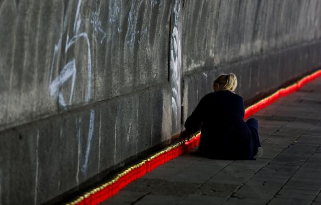 A person lights candles at the so-called "Night of Lights" event to commemorate the victims of a deadly stampede during the 2010 Love Parade festival, at the former festival site on the eve of the disaster's 10th anniversary, in Duisburg, Germany, July 23, 2020. (REUTERS) A person lights candles at the so-called "Night of Lights" event to commemorate the victims of a deadly stampede during the 2010 Love Parade festival, at the former festival site on the eve of the disaster's 10th anniversary, in Duisburg, Germany, July 23, 2020. (REUTERS)