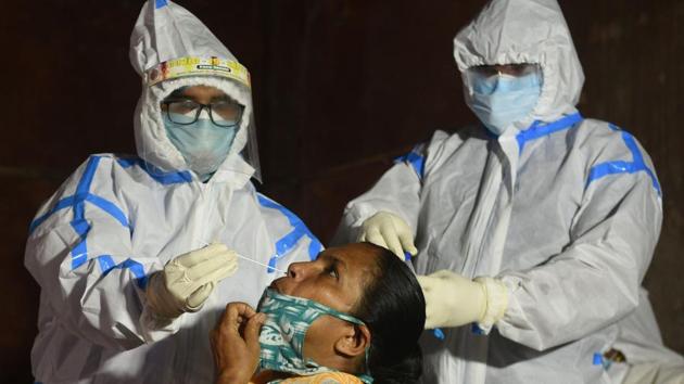 A medical professional in PPE coverall collects swab sample from a woman to test for Covid-19 infection at KMC Ward No. 93 in Gobindapur, in Kolkata, West Bengal on Thursday. (Samir Jana/HT Photo) A medical professional in PPE coverall collects swab sample from a woman to test for Covid-19 infection at KMC Ward No. 93 in Gobindapur, in Kolkata, West Bengal on Thursday. (Samir Jana/HT Photo)
