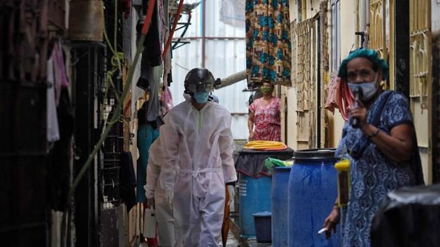 A worker from Bharatiya Jain Sanghatana walks in an alley to screen the residents during a check-up campaign for the coronavirus disease (Covid-19).(REUTERS)